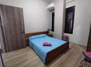 a bedroom with a blue bed with a red object on it at Kavala Summer in Kavála