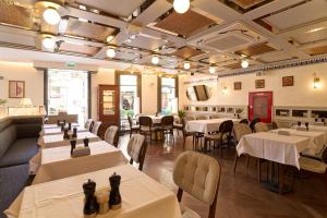 Un restaurante con mesas y sillas en una sala. en The Wings Hotels Pera, en Estambul