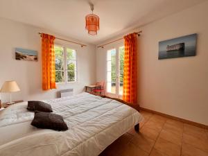 a bedroom with a large bed and two windows at OPALINE maison spacieuse proche plage in Sainte-Marie-de-Ré