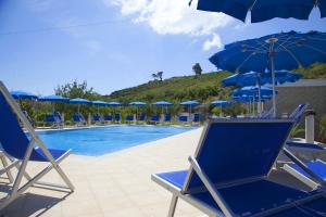 a group of chairs and umbrellas next to a swimming pool at Hotel Residence Villa Ascoli in Vieste
