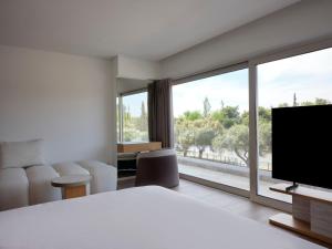 a hotel room with a bed and a large window at Nur Riviera Aparthotel in Athens