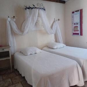 - 2 lits dans une chambre avec des draps et des rideaux blancs dans l'établissement Lei bugadiero, à La Croix-Valmer 12 autres photos