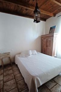 une chambre avec un lit blanc dans une pièce dans l'établissement Lei bugadiero, à La Croix-Valmer