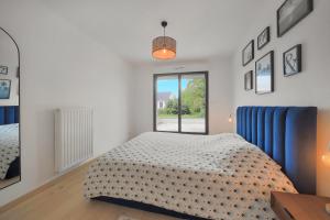una camera da letto bianca con un letto e una finestra di La Villa Sainghin - Piscine et Jacuzzi Privé a Sainghin-en-Mélantois Altre 18 foto