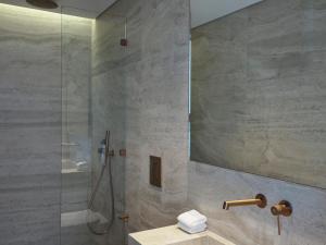 a bathroom with a shower with a sink and a mirror at Nur Riviera Aparthotel in Athens