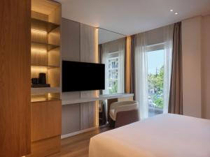 a hotel room with a bed and a flat screen tv at Nur Riviera Aparthotel in Athens