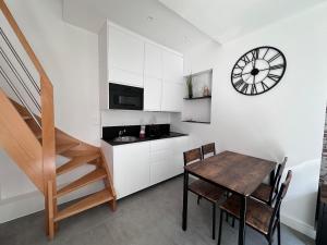 a kitchen with a table and a clock on the wall at L'épicurieux in Lille