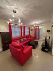 a living room with red furniture and a chandelier at Hara Villa in Bijela