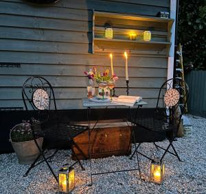 a table with candles and flowers on a patio at Hillhead Hideaway in Saint Columb Major