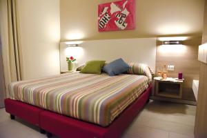 a small bedroom with a bed with a colorful blanket at Costa Verde Natura in Clusane sul Lago