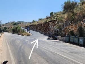 a road with a white arrow on the side of a hill at Villas Ermali in Ksamil