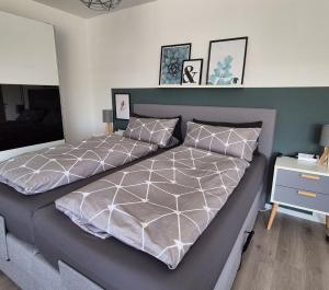 a bedroom with a large bed with a gray bedspread at Ferienwohnung Villa Grimm in Burbach