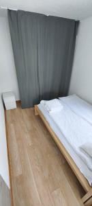 a bedroom with a bed and a wooden floor at Audronašų Vilų Nameliai in Šventoji