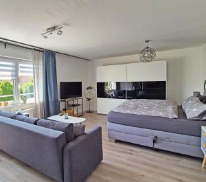 a bedroom with a bed and a couch at Ferienwohnung Villa Grimm in Burbach