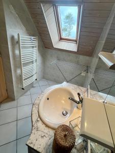 a white bathroom with a sink and a window at Gites de la Mouette Le Bigorneau nid cotier 2 personnes in Ravenoville +10 photos