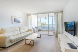 カジャオ・サルバヘにあるOcean Breeze Apartmentsの白いソファとテレビのあるリビングルーム