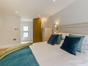 a bedroom with a large white bed with blue pillows at 3 Bed in Hartland 91183 in Hartland