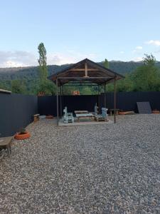 a gazebo with a picnic table and benches at The Mountain A-Frame Qusar in Yuxarı Lǝgǝr