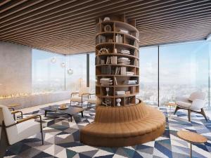 a living room with a spiral book shelf and chairs at NH Sintra Centro in Sintra