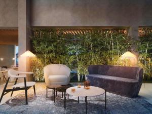 a living room with a couch and a table and chairs at NH Sintra Centro in Sintra