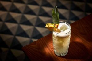 a drink with a green leaf on top of a table at NH Sintra Centro in Sintra