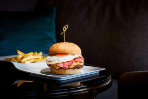 a sandwich on a plate next to a plate of fries at NH Sintra Centro in Sintra