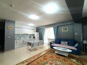 a living room with a blue couch and a kitchen at OUNT-Central location, spacious, cozy and secure in Ulaanbaatar