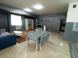 a living room with a table and a couch at OUNT-Central location, spacious, cozy and secure in Ulaanbaatar