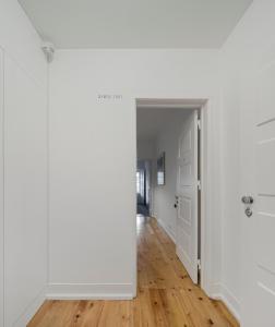 um corredor vazio com paredes brancas e pisos de madeira em Flattered to be in Tomar em Tomar