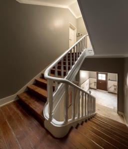 a staircase with a white rail and wooden floors at Flattered to be in Tomar in Tomar