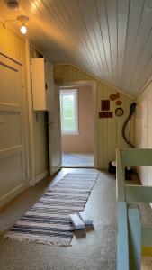 an attic room with a rug on the floor and a door at Lofoten view Skokkelvika in Valberg +23 photos