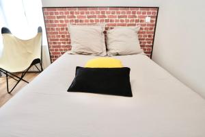 ポンティヴィにあるL'Ocre - Wifi - 400m centre Pontivyのレンガの壁のある部屋にあるベッド