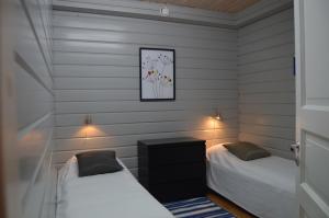 Habitación pequeña con 2 camas y paredes blancas. en Tahkonranta, en Tahkovuori