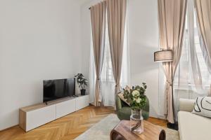 Una sala de estar con un televisor, un sofá y una mesa. en Close to Metro, 10 Minutes to Mariahilferstraße, en Viena