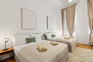 Dos camas en una habitación con paredes blancas. en Close to Metro, 10 Minutes to Mariahilferstraße, en Viena