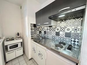 a kitchen with a sink and a stove at Bruyant studio proche centre, terrasse et parking in Reims