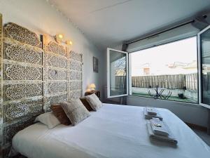 a bedroom with a large bed and a large window at Bruyant studio proche centre, terrasse et parking in Reims