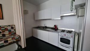 a white kitchen with a stove and a sink at Residenza Talponia 250 in Ivrea