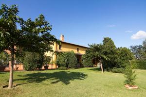 a house with a tree in the yard at Podere Villabassa in Montespertoli