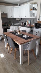a kitchen with a wooden table and chairs at Chill and Relax Apartman Kehidakustány in Kehidakustány