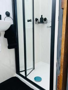 a shower with a glass door in a bathroom at Hillhead Hideaway in Saint Columb Major +16 photos