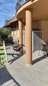 a group of chairs and tables on a patio at Chill and Relax Apartman Kehidakustány in Kehidakustány