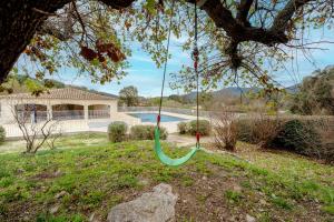 普朗德拉图尔Superbe Appartement climatisé dans résidence avec Piscine et parking的树上挂着的绿色秋千