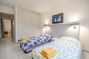 普朗德拉图尔Superbe Appartement climatisé dans résidence avec Piscine et parking的一间卧室配有两张带蓝白色床单的床