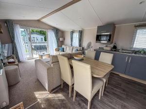 ハンスタントンにあるBeautiful Caravan With Decking At Manor Park In Hunstanton Ref 23042Bのテーブルと椅子のあるキッチンとリビングルーム