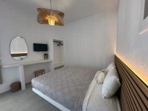 a small bedroom with a bed and a mirror at Danа̃e Sun&Sea Stays in Livadion +6 photos