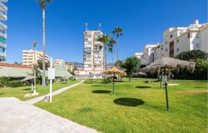 a park with straw umbrellas in the grass at Beautiful Apartment In Benalmadena in Benalmádena +13 photos