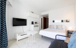 a white bedroom with a bed and a tv at Beautiful Apartment In Benalmadena in Benalmádena