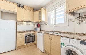 a kitchen with white appliances and a washer and dryer at Awesome Home In Avileses in Avileses