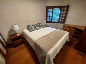 Ένα ή περισσότερα κρεβάτια σε δωμάτιο στο apartamento capivari campos do jordão